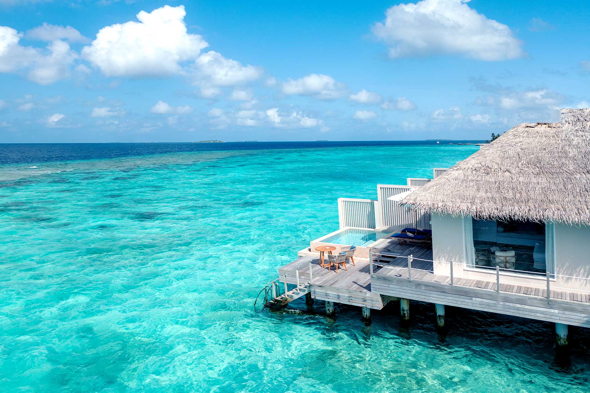 Water villa with private plunge pool over turquoise Maldives lagoon